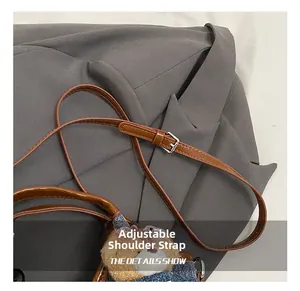 Detail view of denim bucket bag with adjustable leather strap and cute bear charm