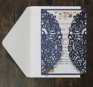 Detailed laser-cut rose pattern on navy blue wedding invitation with white insert card
