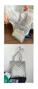 Silver woven tote bag with hollow design and inner drawstring pouch shown in usage