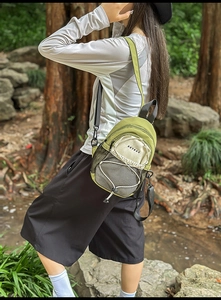 Détail du sac bandoulière en nylon vert olive avec poche en filet dans la forêt
