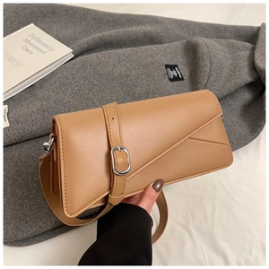 Detailed macro view of tan rectangular leather bag with silver buckle and geometric stitching