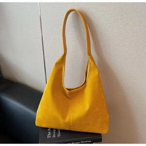 Detailed view of yellow oversized tote bag with vertical stitching on a minimalist sofa