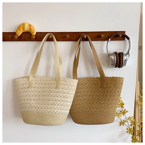 Detail of hand-woven crochet tote bags in beige and khaki colors hanging on wood hooks