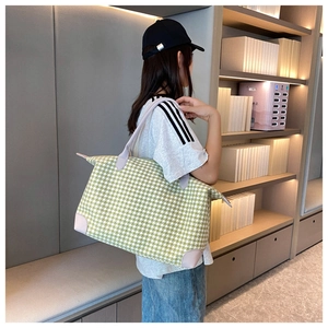 Détail d'un grand sac fourre-tout avec motif pied-de-poule vert et finitions en cuir rose