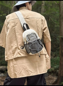 Vue extérieure d'un sac de poitrine multifonctionnel en nylon blanc cassé avec filet noir
