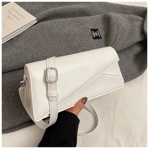 Detail of white leather shoulder bag with asymmetric flap and silver square buckle