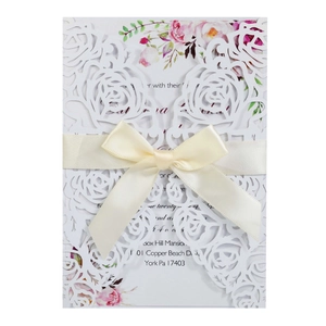 Elegant laser-cut floral wedding invitation with watercolor roses and a satin ribbon bow
