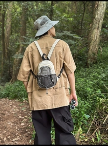 Vue arrière d'un mini sac à dos en nylon avec poches filet et cordon élastique de sport