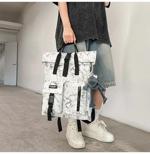 Detail of canvas backpack featuring black marble texture and secure buckle closure