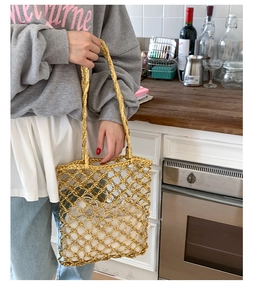 Detail of gold metallic woven tote bag with a white cotton drawstring inner lining bag