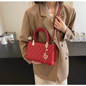Detail of red quilted tote bag with gold heart pendant and囍charms for wedding