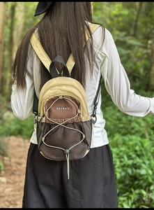 Photo de style plein air d'un mini sac à dos en nylon kaki avec cordon de serrage