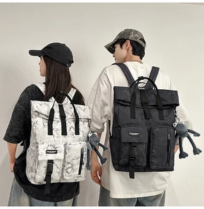 Detail view of marble pattern and black couple backpacks with front utility pockets