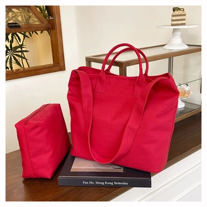 Detail of red canvas tote bag set including a large tote and a matching small zipper pouch