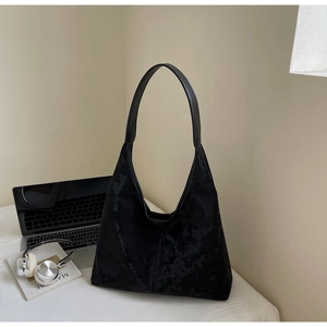 Detail of black velvet tote bag texture shown in a minimalist office setting