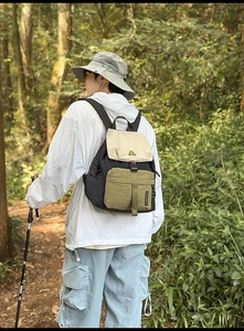 Detailed outdoor view of a tricolor nylon hiking backpack featuring a rustic forest vibe