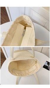 Internal view of beige woven tote bag showing fabric lining and secure zipper pockets