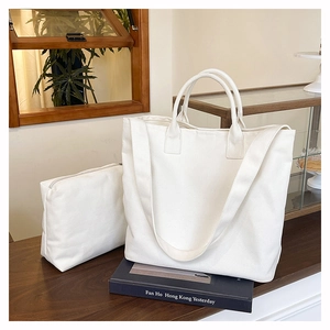 Detailed set of white canvas tote and small zipper pouch on a wooden table setup