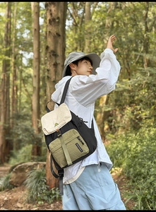 Side view of multi-color nylon outdoor backpack featuring a flap cover in forest setting