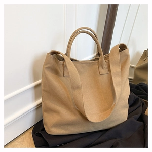 Detail view of khaki canvas tote bag with fixed handles and wide shoulder strap