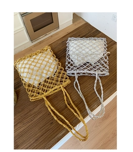 Top view of gold and silver hollow woven tote bags with white inner linings on wood surface