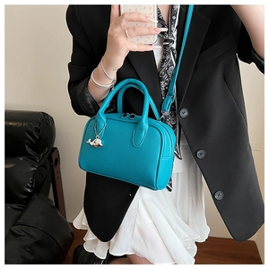 Close-up of bright blue lychee texture mini bowling bag with silver whale pendant