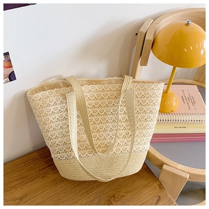 Detailed close-up of ivory lace crochet tote with durable woven straw bottom and lining