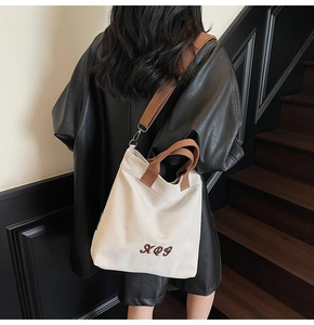 Rear view of minimalist canvas tote bag with adjustable straps on a model in leather jacket