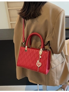 Red quilted tote bag with woven handles and golden wedding heart pendant decoration