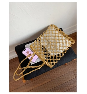 Macro view of golden woven mesh tote bag with a white drawstring canvas inner pouch