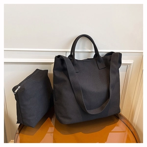 Detail view of black canvas tote bag set with matching zippered pouch and wide strap