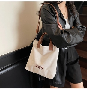 Retro canvas tote bag with adjustable strap worn as a stylish crossbody on a model