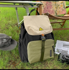 Close-up of the contrast color outdoor backpack with smiley patch and side drawstring detail