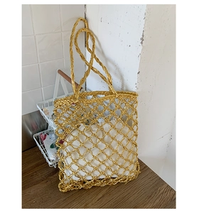 Detail of gold metallic woven hollow tote bag with a white drawstring inner pouch