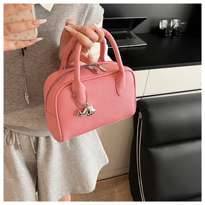 Pink pebbled leather bowling bag detail with silver whale pendant and metal zipper