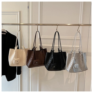 Detailed view of woven leather tote bags in four colors with matching mini pouches