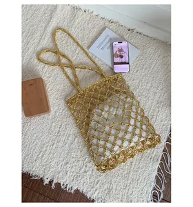 Detail of gold metallic hollow woven tote bag with a white inner canvas pouch