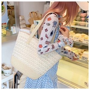 Detailed close-up of lace crochet and woven straw texture on a large beige tote bag