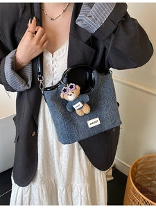 Blue denim tote bag with black glossy handles and a cute bear charm for daily commute