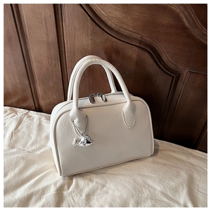 Detail of white lychee grain bowling bag with silver zipper and whale metal charm