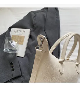 Dettaglio borsa beige in pelle stropicciata con fibbie in metallo argentato lucido e finiture