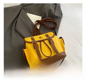 Detail view of contrast yellow and brown backpack featuring embroidery and dual straps