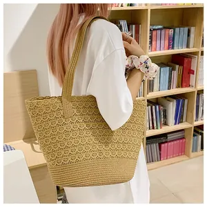 Lifestyle view of large woven straw tote bag with hollow knit texture for summer beach trips