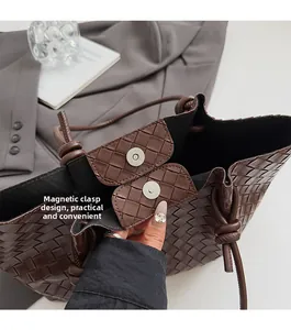 Detail view of woven brown leather tote bag featuring a convenient magnetic clasp closure