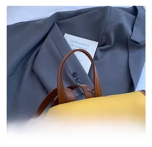 Detail of travel backpack featuring a curved top handle and magnetic metal fasteners