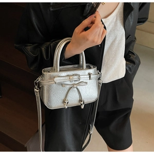 Silver metallic bucket bag detail with stylish bow decoration and pleated texture