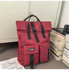 Detail of burgundy marble texture backpack with roll-top buckle and multi-pocket design