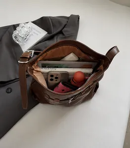 Detail view of large interior capacity showing iPad, books and umbrella in tote bag
