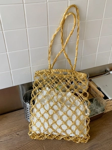 Metallic gold knit tote bag with mesh hollow design and white drawstring inner pouch