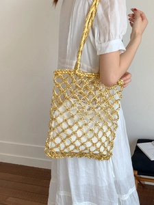 Metallic gold woven tote bag with drawstring canvas liner and shoulder strap